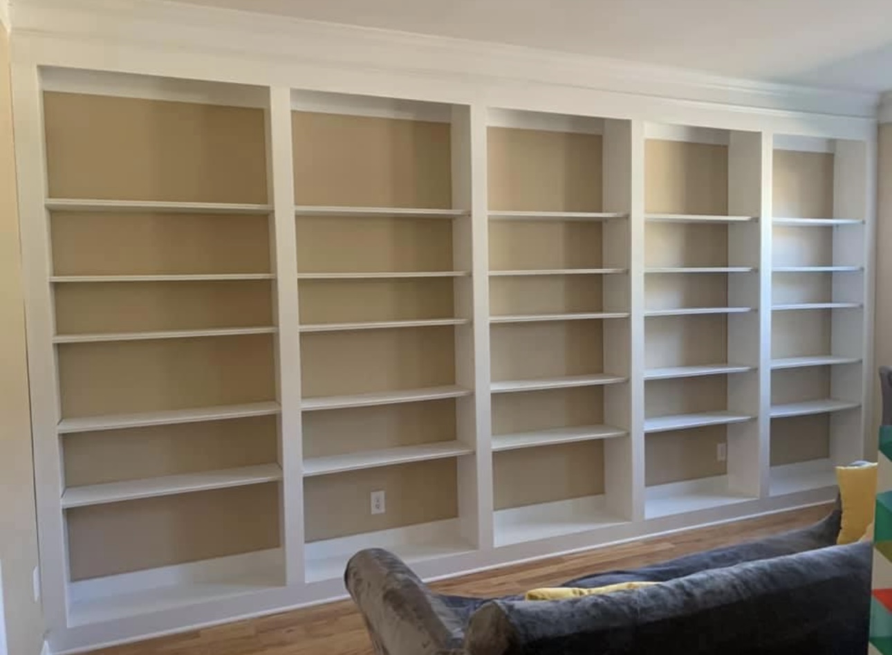 Full wall white bookshelves
