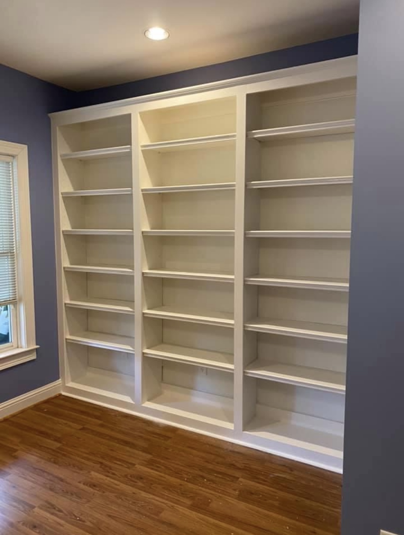 Three-section white bookshelf wall