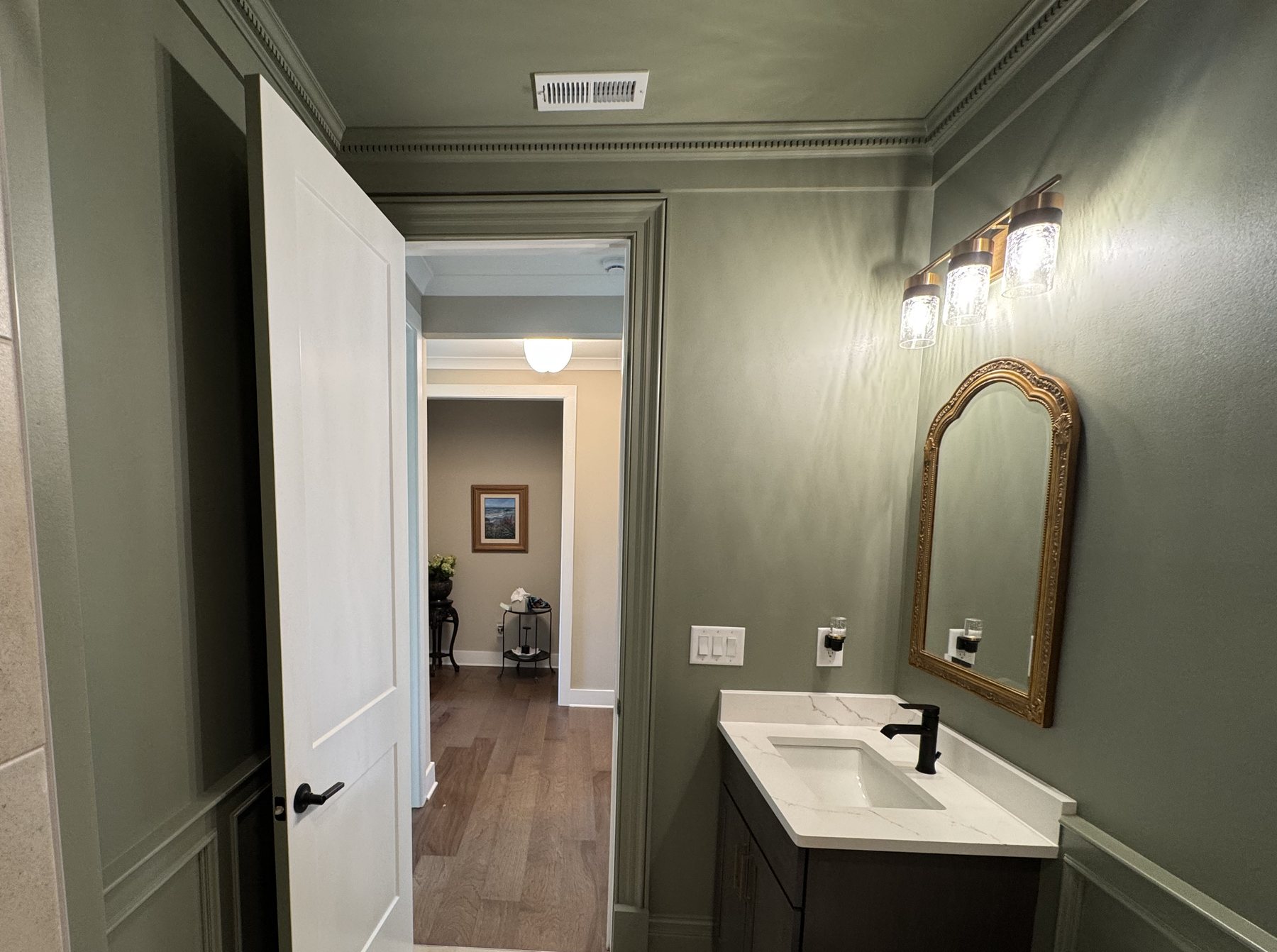 Open door with picture-frame casing under a frieze and dentil crown