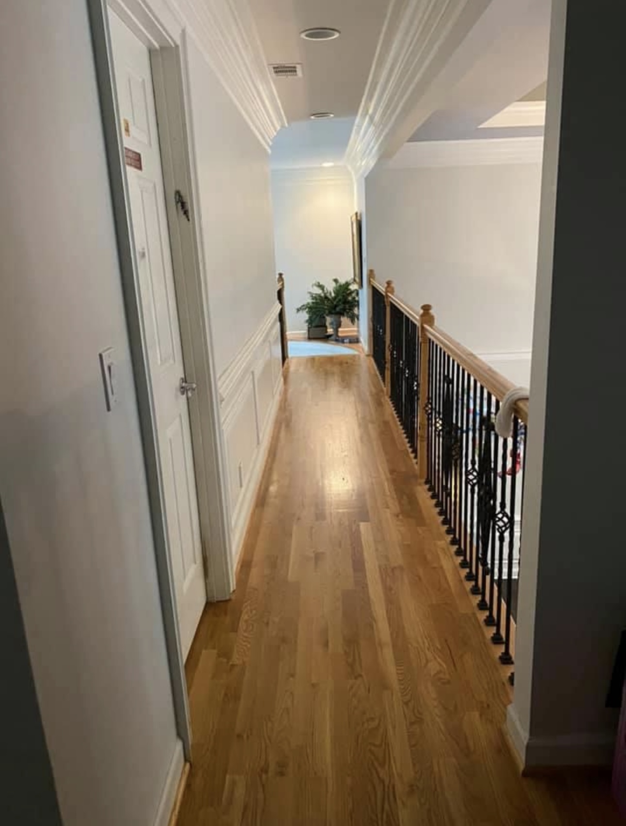 Hallway with crown moulding and wainscoting